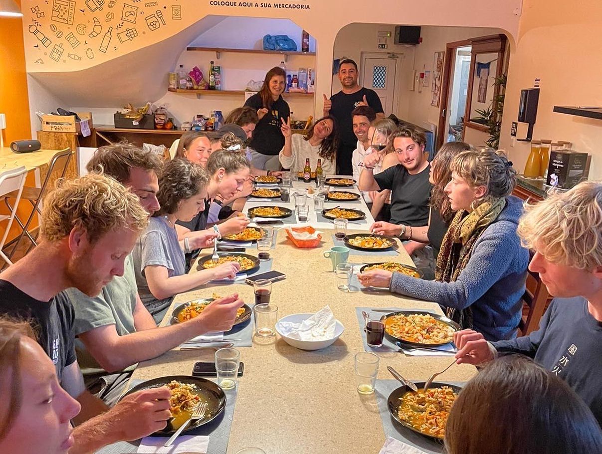 A group of people are sitting at a long table eating food.