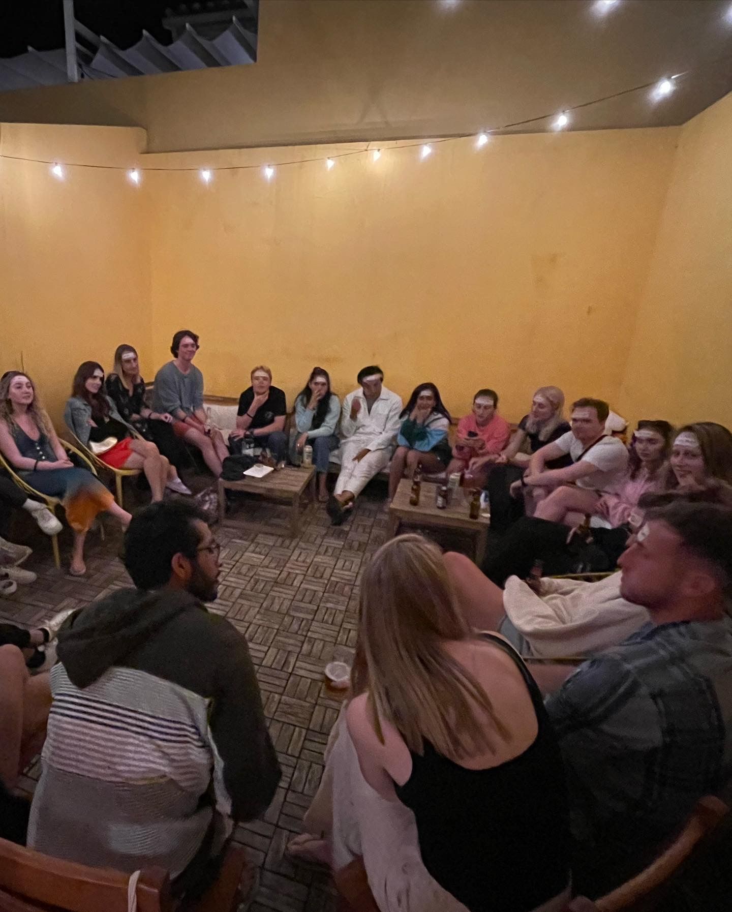 A group of people are sitting in a circle in a room.