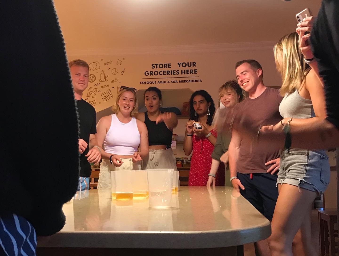 A group of people standing around a table with a sign that says store your groceries here