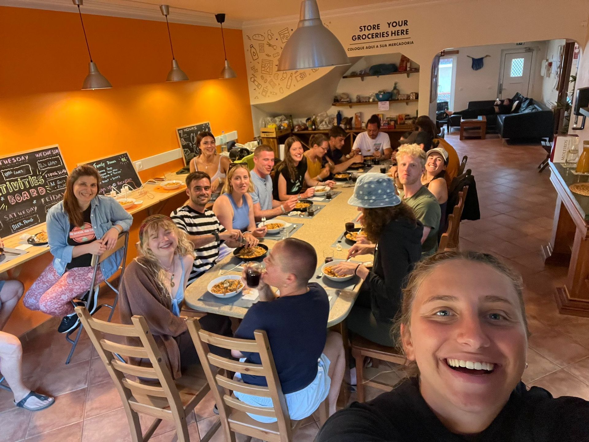 A group of people are sitting at a long table eating food.