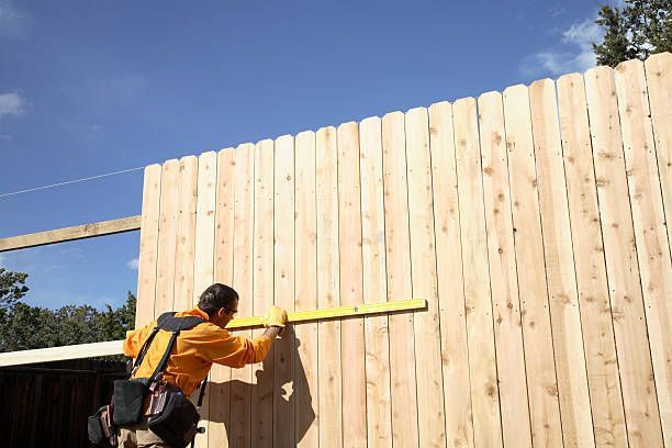 An experienced fence installation contractor building a wood fence.