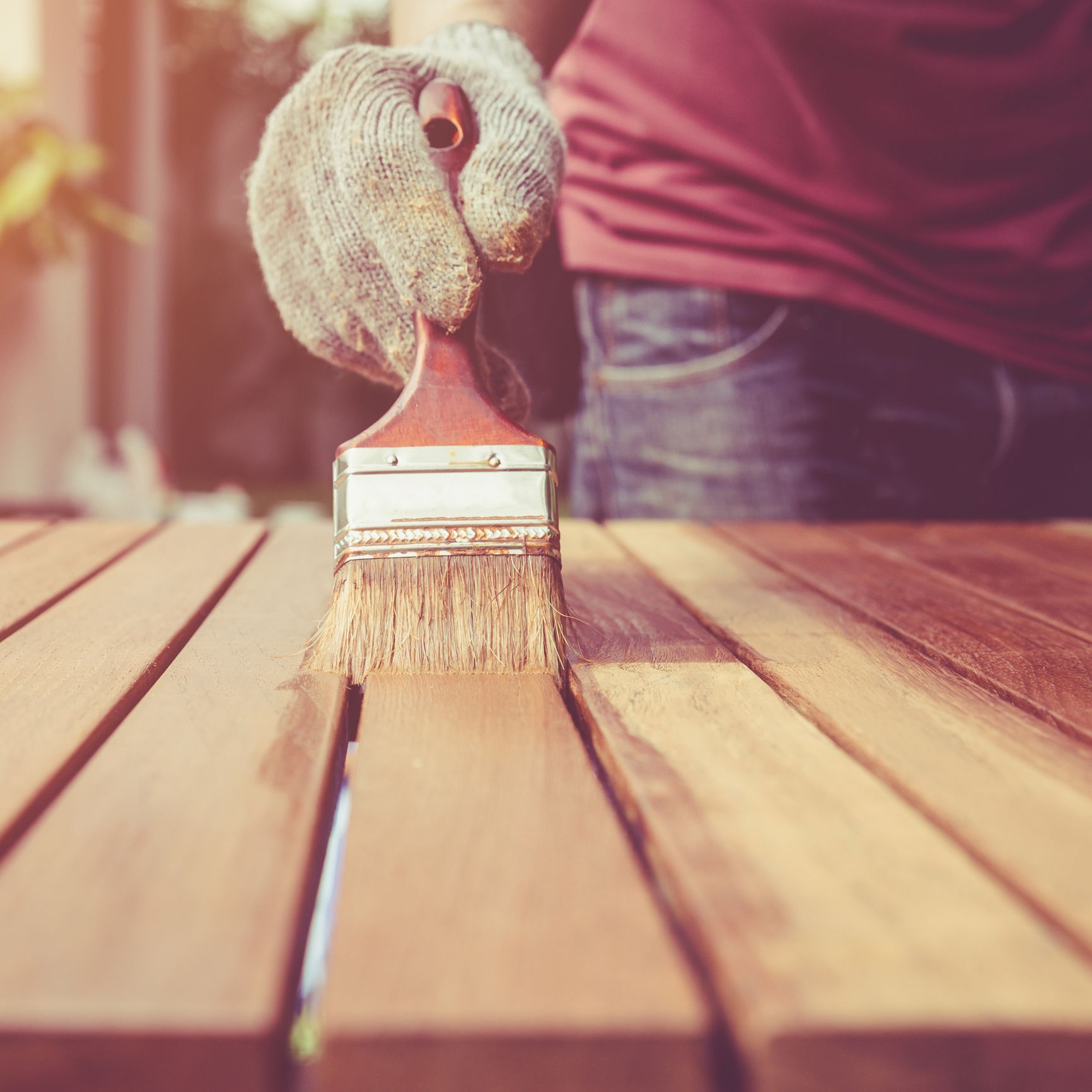 Closeup of hand painting a wooden surface, representing fence repair services. Closeup of hand painting a wooden surface, representing fence repair services.
