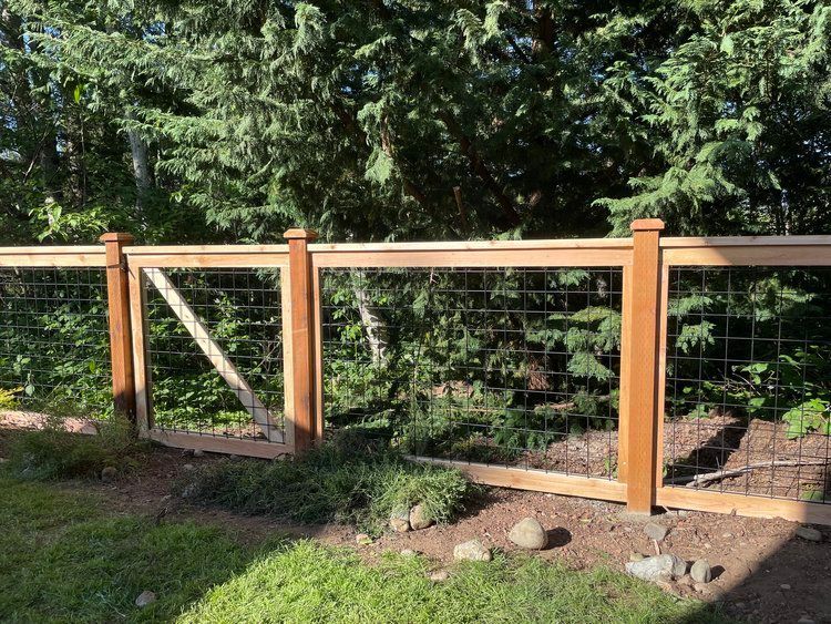A Wooden Fence Is Surrounded by Trees and Grass | Issaquah, WA | Neighborly Fencing
