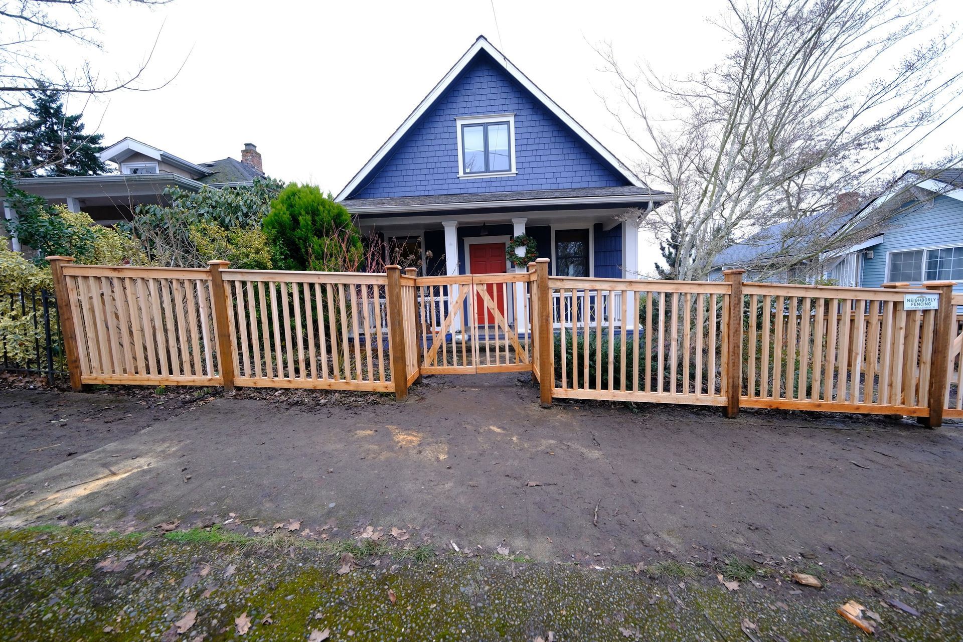 A wooden fence surrounds a lush green yard.