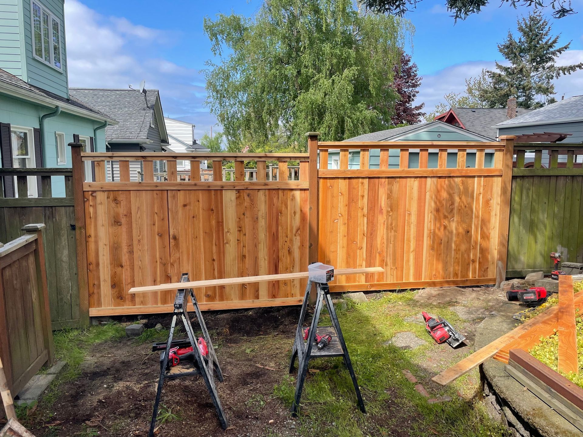 Two Men Are Working on A Wooden Fence in A Backyard | Issaquah, WA | Neighborly Fencing