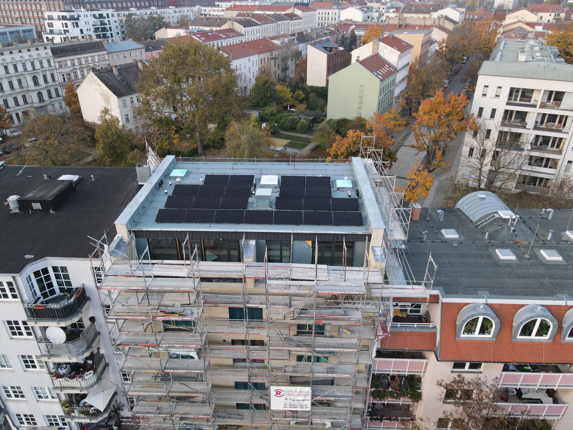 An aerial view of a building with solar panels on the roof