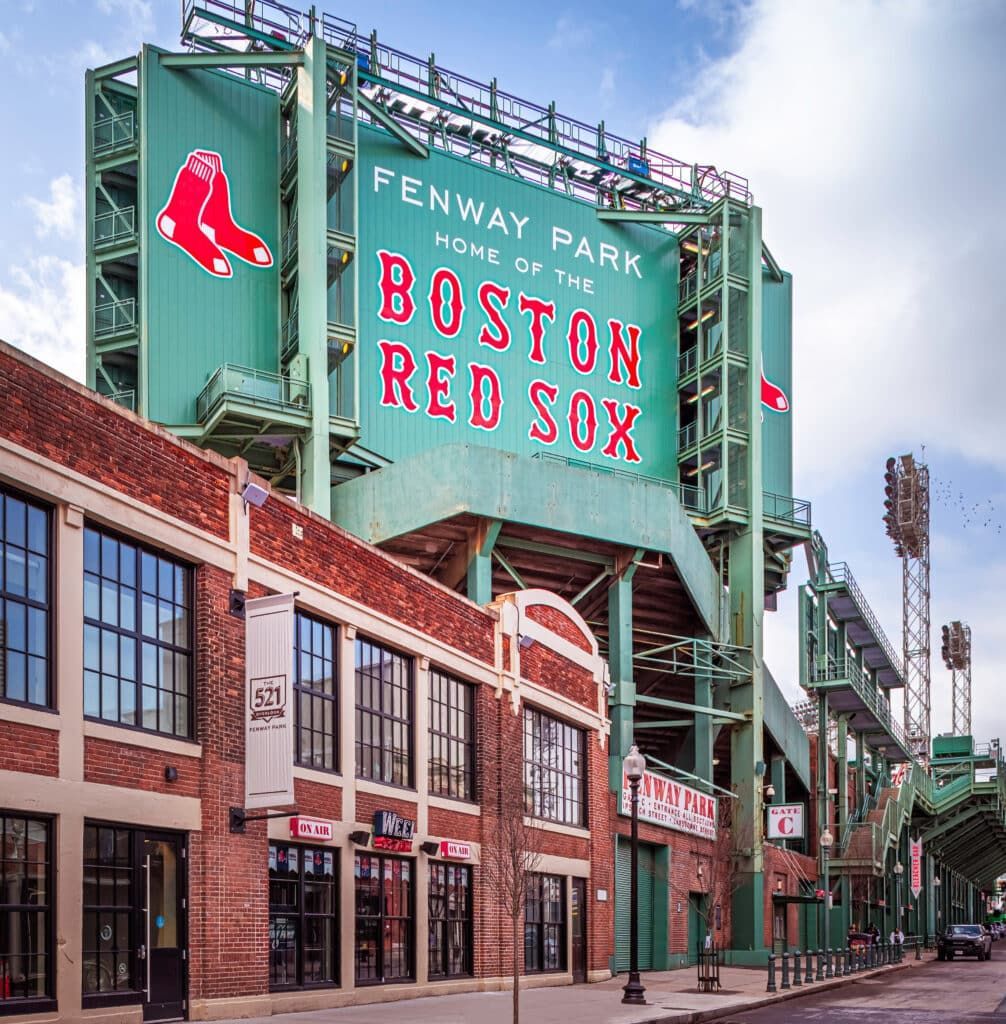 Fenway Park facade with the Green Monster, Boston Red Sox logo, and shops.