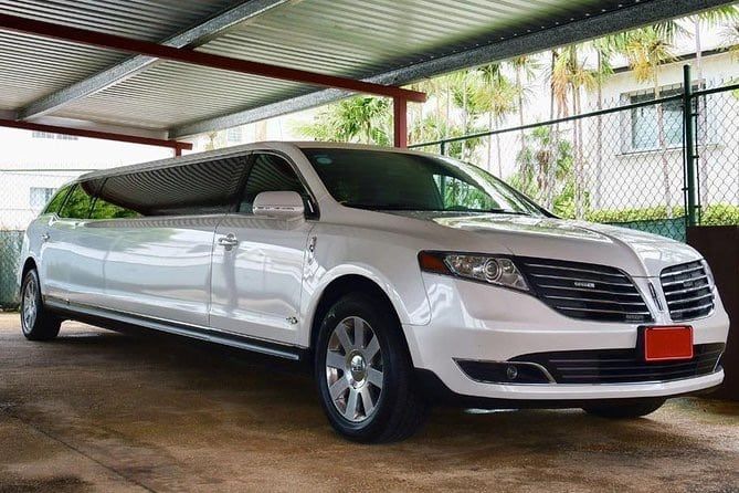 White Lincoln limousine parked under a metal awning.