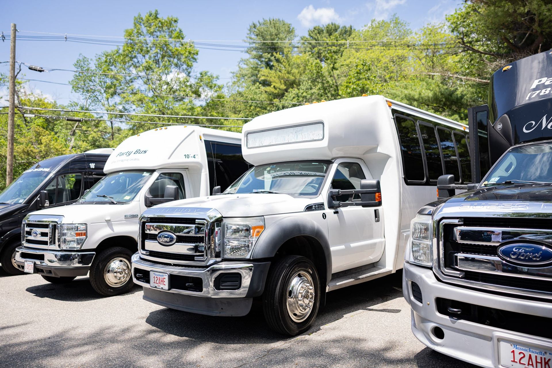 Several white and black passenger vans parked outdoors.