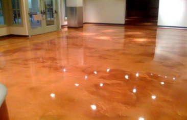A shiny concrete floor in a room with a lot of lights on it.