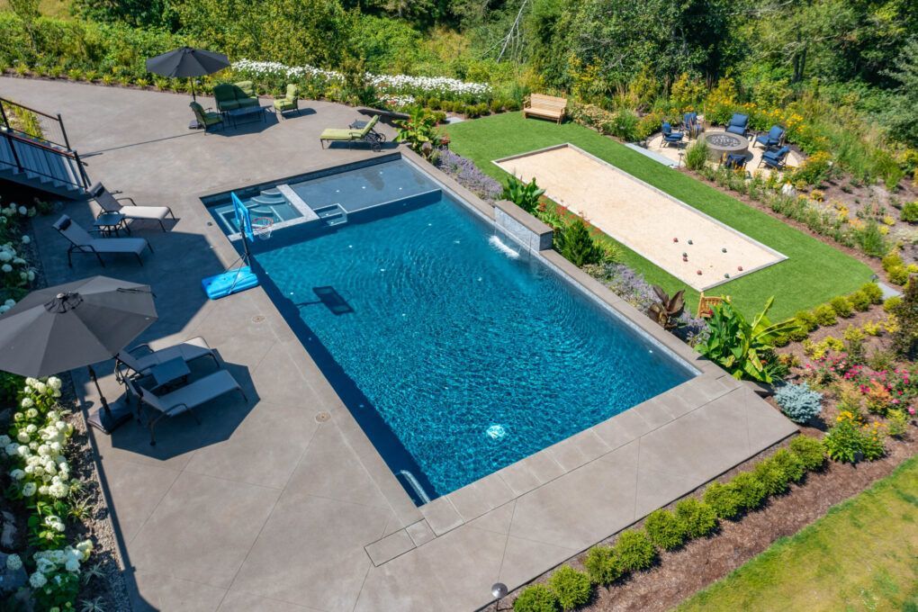 concrete patio surrounding swimming pool