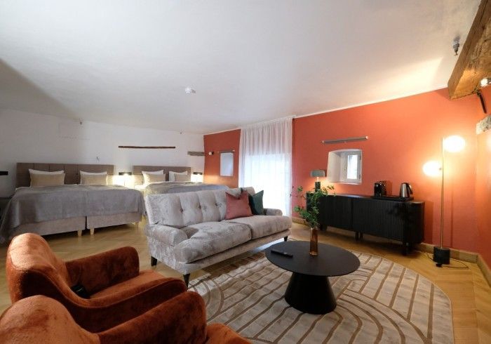 A living room with a couch , chairs , and a coffee table.