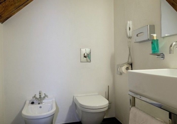 A bathroom with a toilet a sink and a bidet