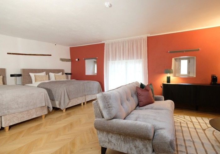 A living room with a couch and two beds