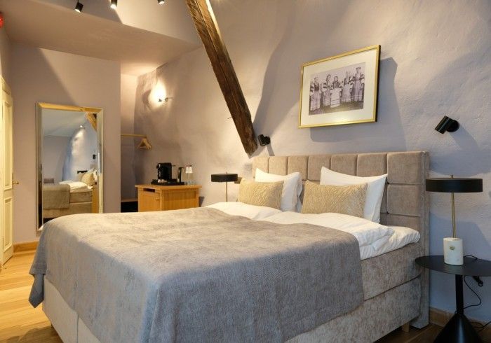 A hotel room with a large bed and a picture on the wall