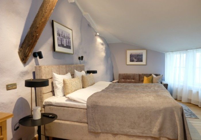 A hotel room with a large bed and a couch