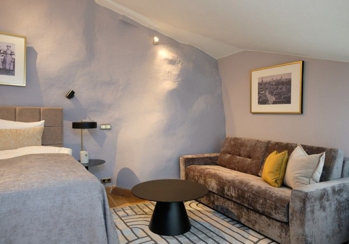 A bedroom with a bed a couch and a table