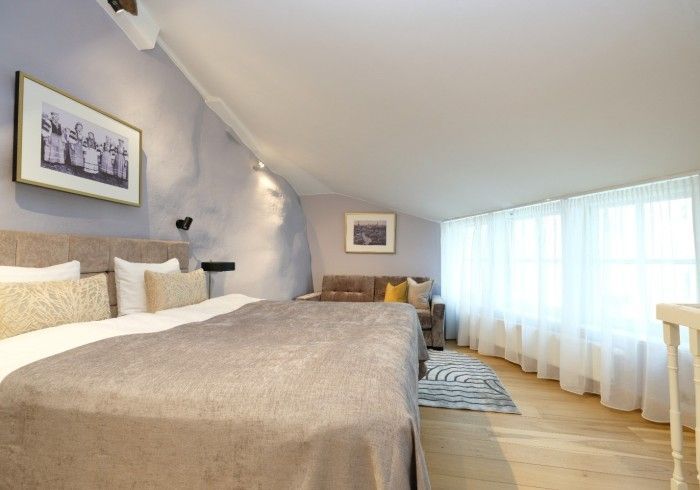 A hotel room with a large bed and a couch