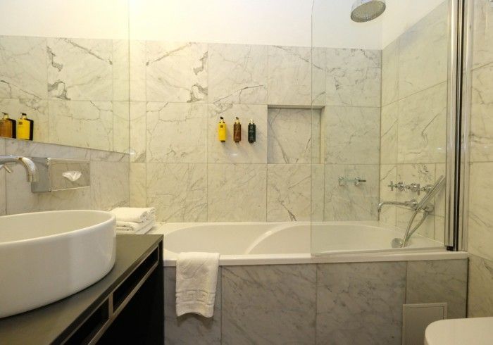 A bathroom with a bathtub , sink , toilet and shower.