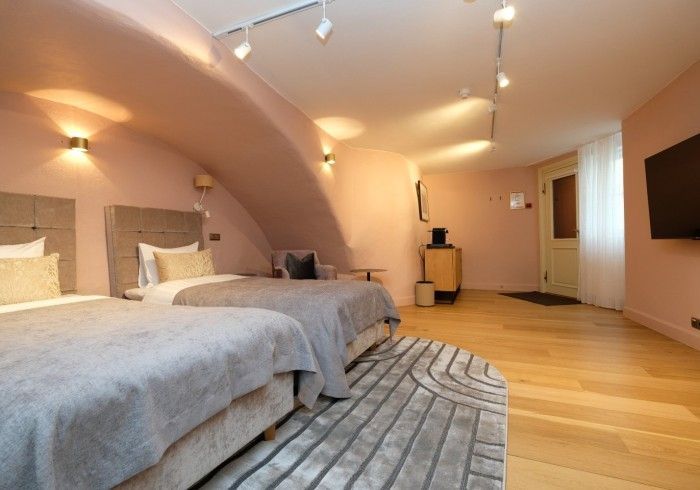 A hotel room with two beds and a flat screen tv.