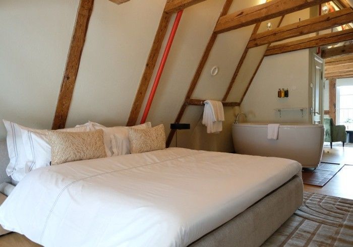 A bedroom with a king size bed and a bathtub