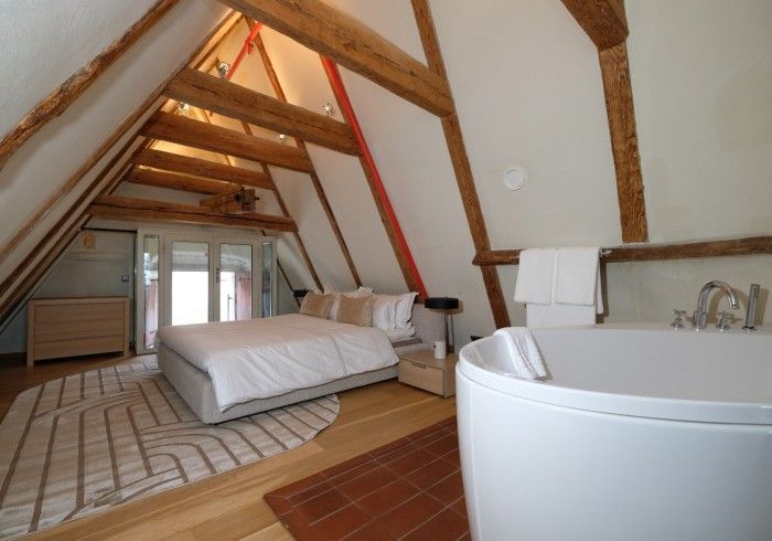 A bedroom with a large bed and a bathtub