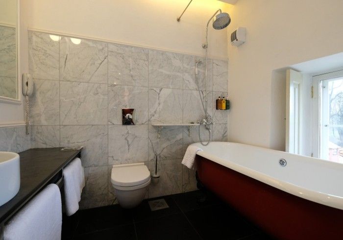 A bathroom with a bathtub , toilet , sink and shower.