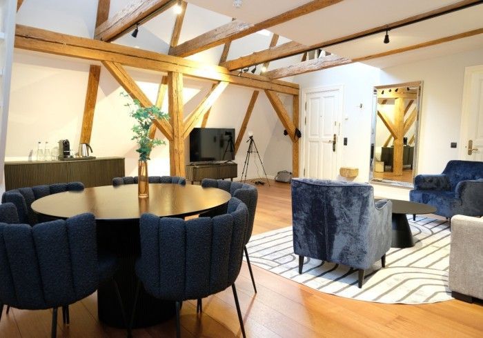 A living room with a round table and blue chairs