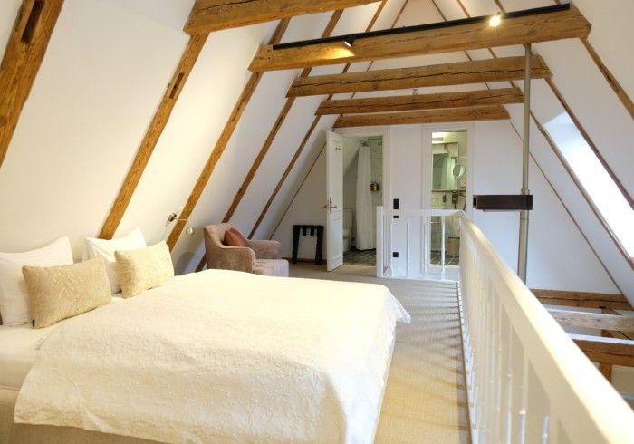 A bedroom with a bed and a chair in it