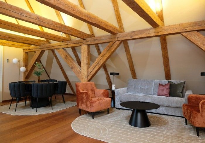 A living room with a couch , chairs and a table