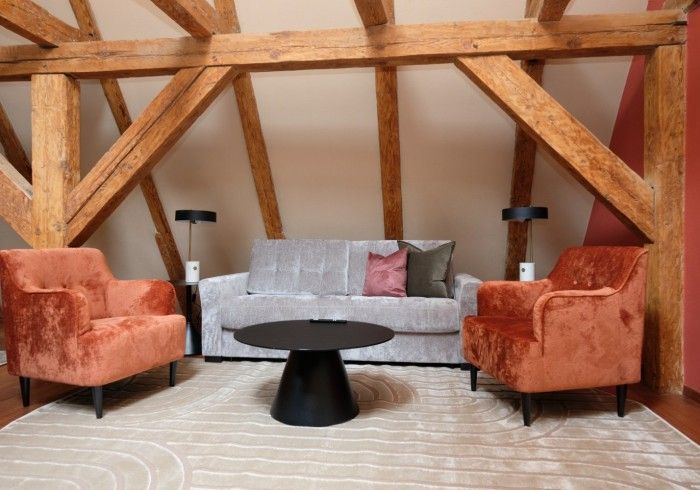 A living room with a couch and two chairs