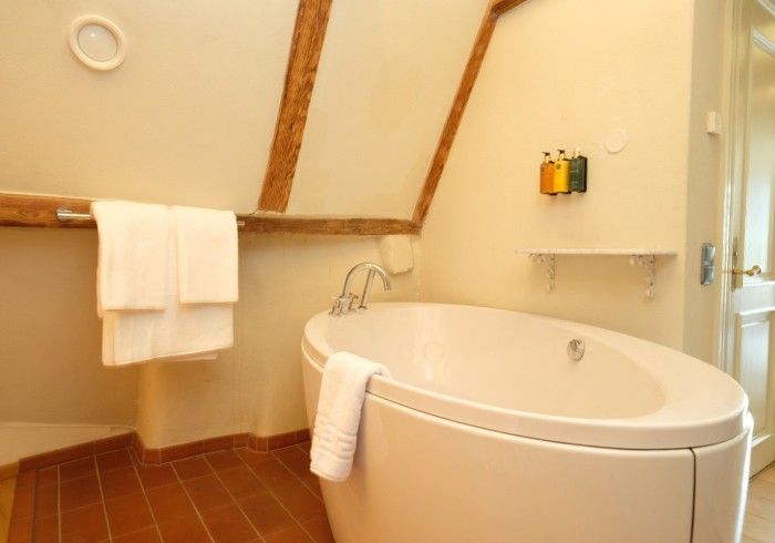 A bathroom with a bathtub and towels on the wall