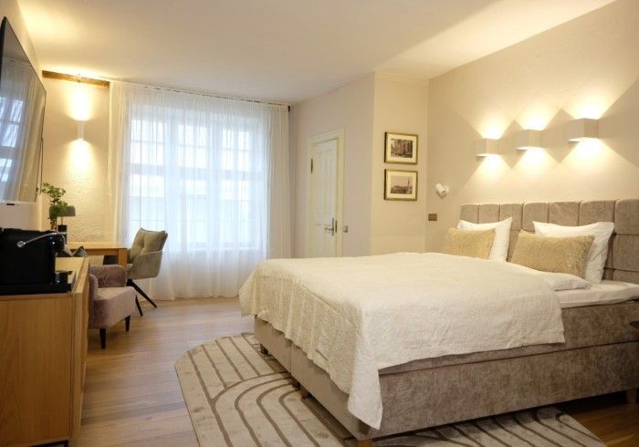 A hotel room with a large bed and a television