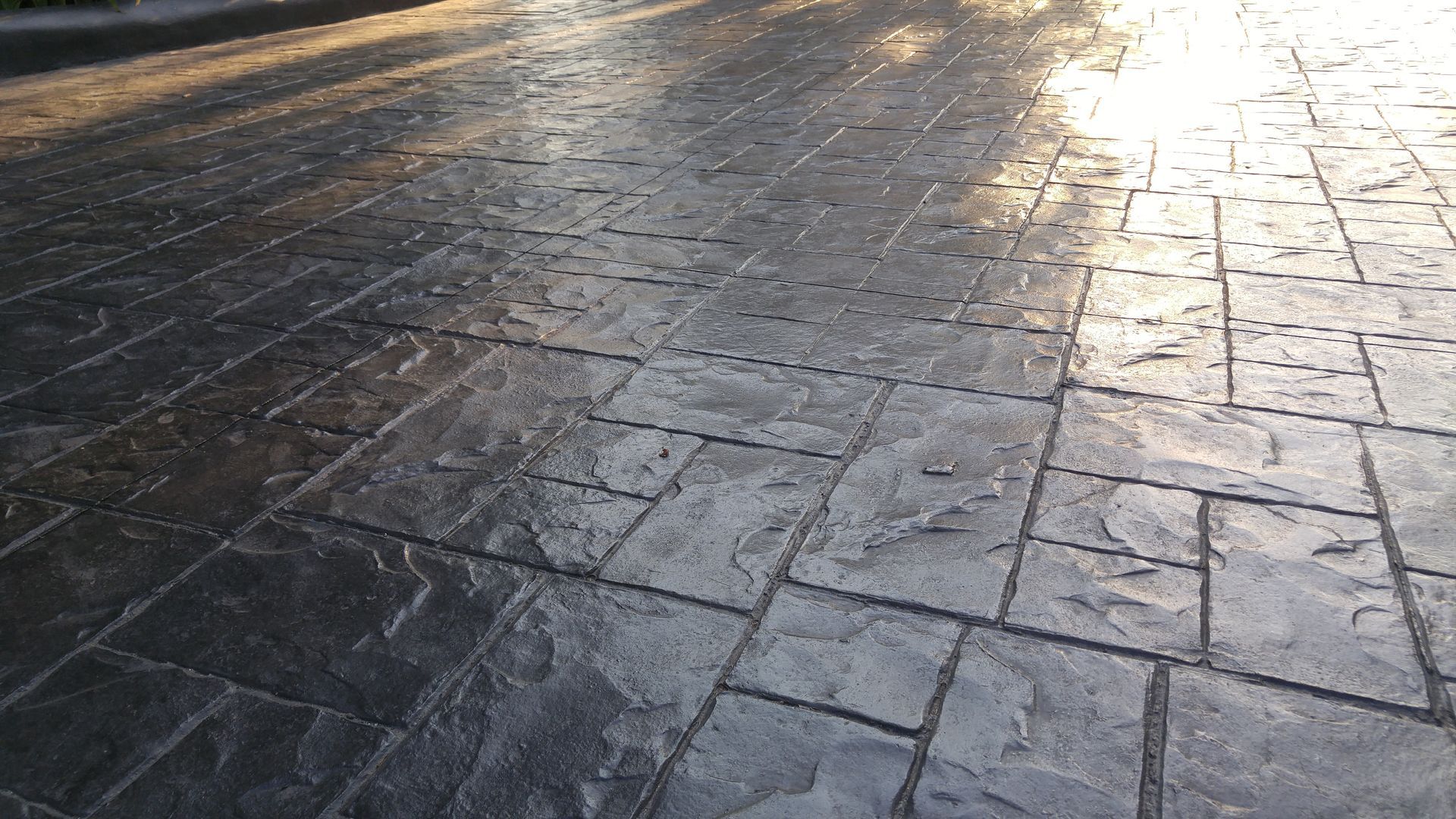 A close up of a brick pavement with the sun shining on it.