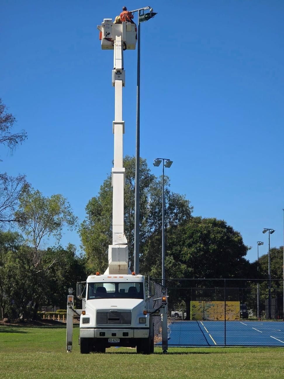 Helping Electrical Change Out Lights On The Netball Courts — Emerald Tree Services Pty Ltd in Emerald, QLD