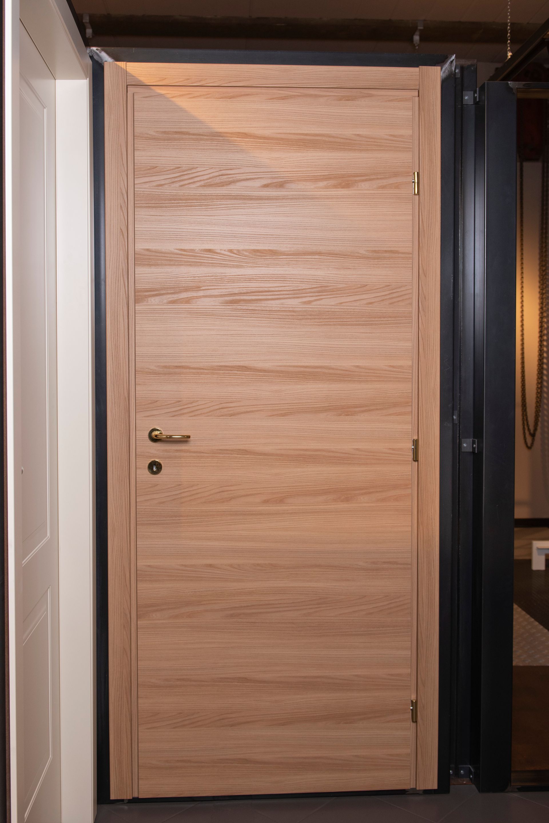 Porta interna in legno chiaro con venature orizzontali.