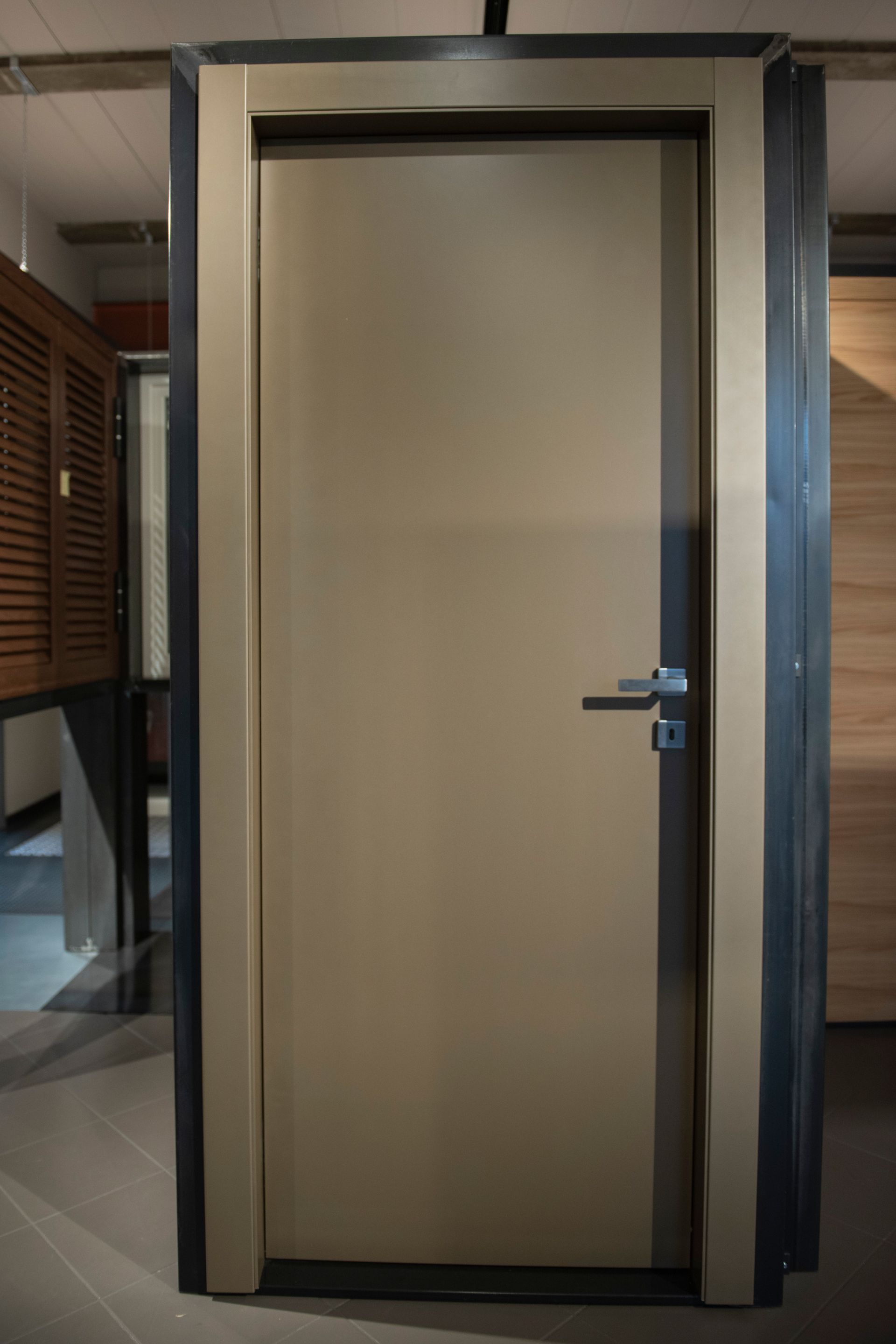 Porta interna beige con finiture e maniglia grigio scuro.