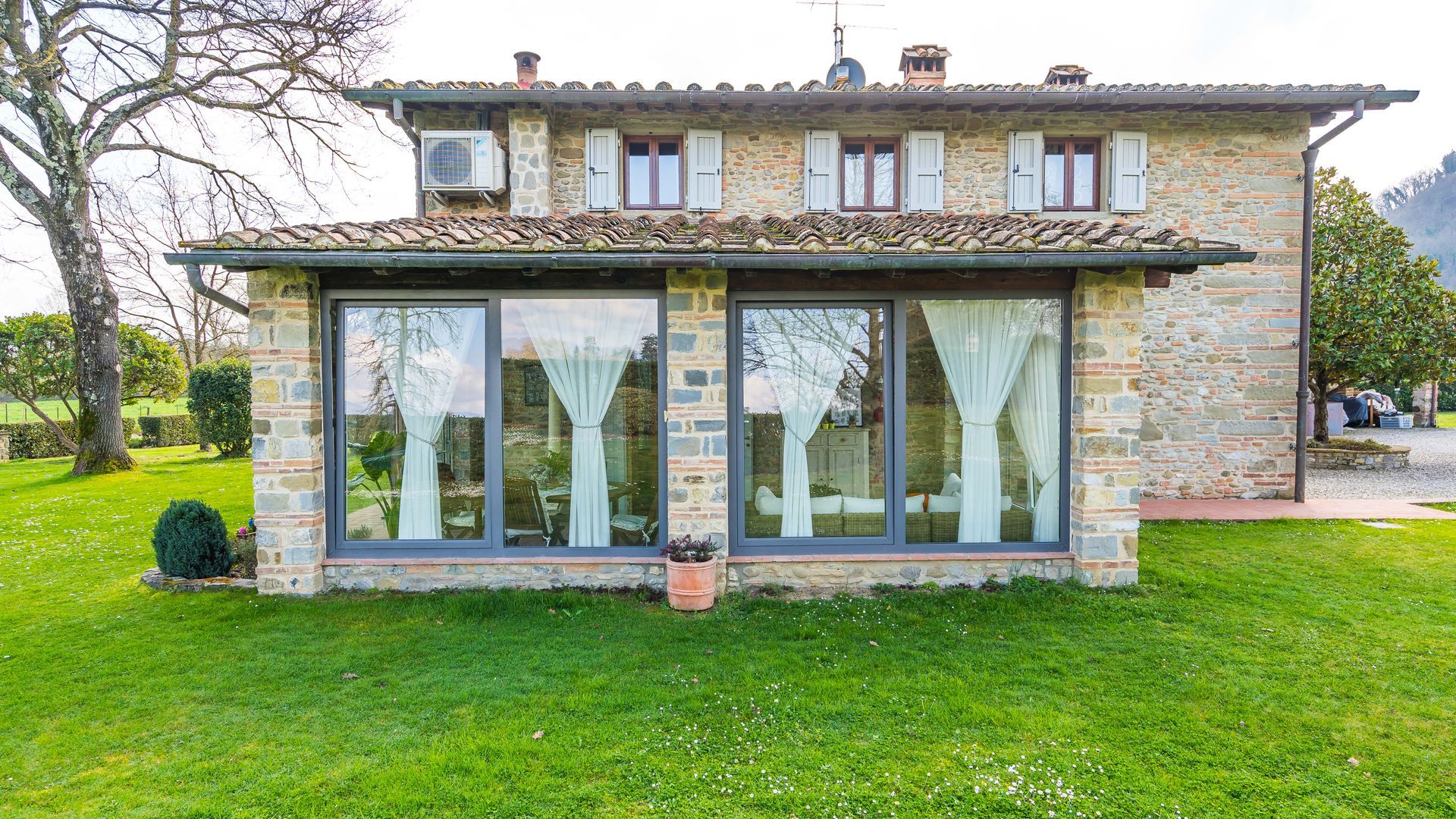 Finestra con inferriate e pannelli aperti, fiancheggiata da persiane verdi. Vista interna, luce del sole che filtra dalla finestra.