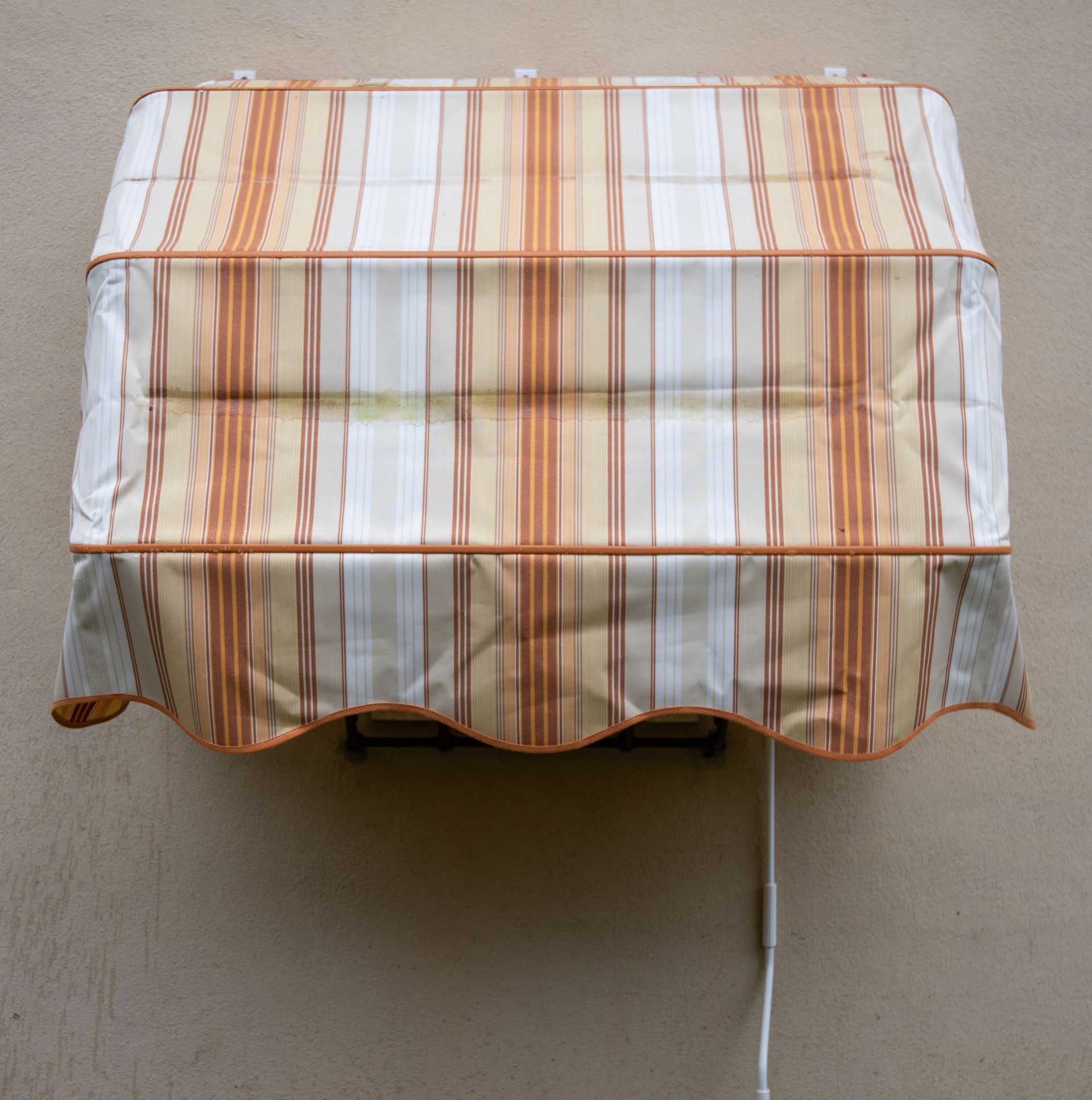 Tenda a strisce su parete beige.