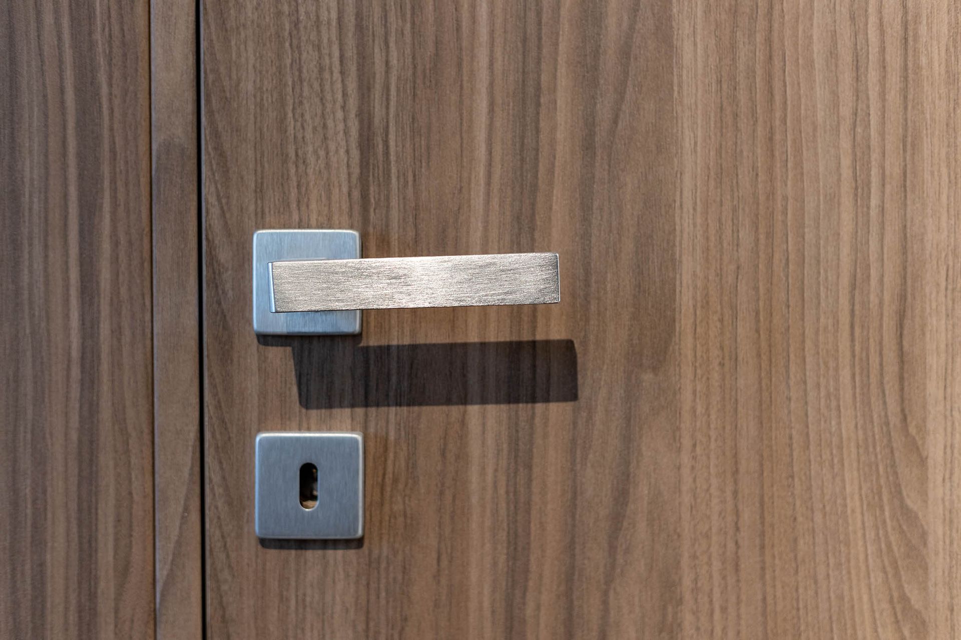 Porta in legno con maniglia e serratura argentate.