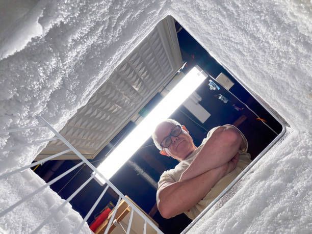 A man is standing in a hole in a wall with his arms crossed