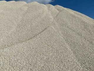A large pile of sand against a blue sky.