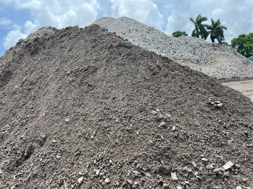 A large pile of dirt and rocks is sitting on top of a dirt hill.