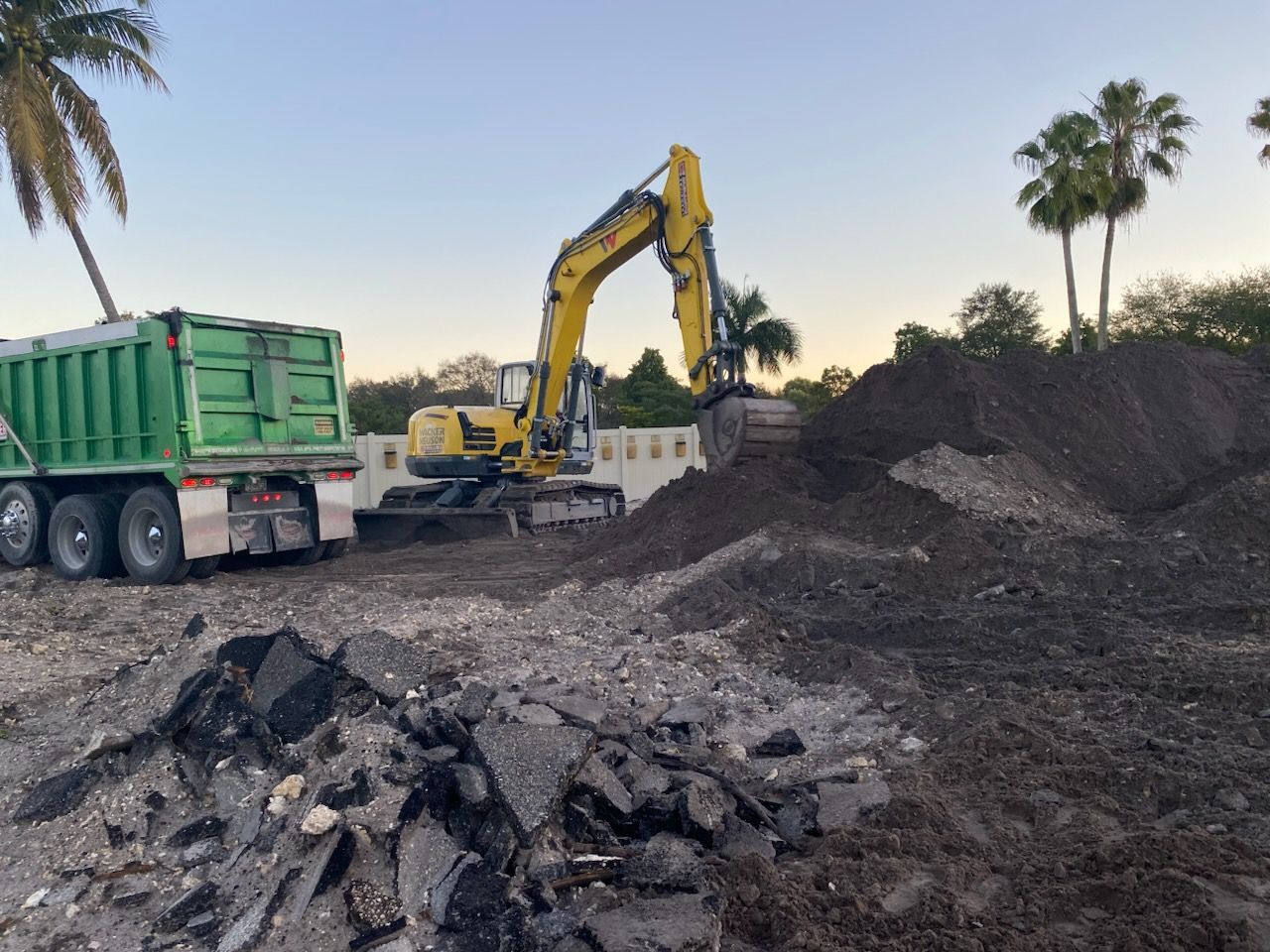 An excavator is loading dirt into a dump truck.