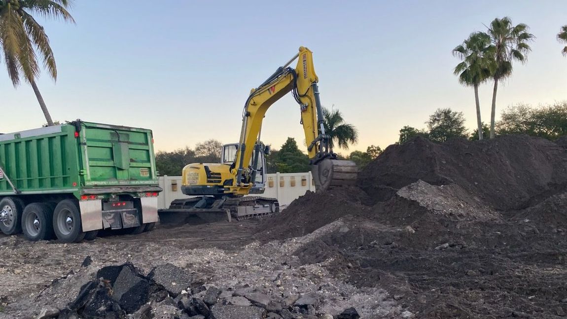 An excavator is loading dirt into a dump truck.