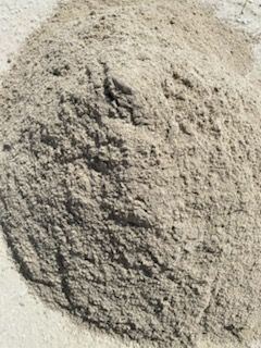A pile of sand is sitting on top of a concrete surface.