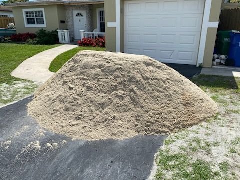 A pile of sand is sitting in front of a house