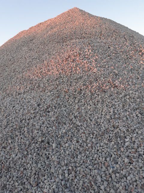 A large pile of gravel is sitting on top of a hill.