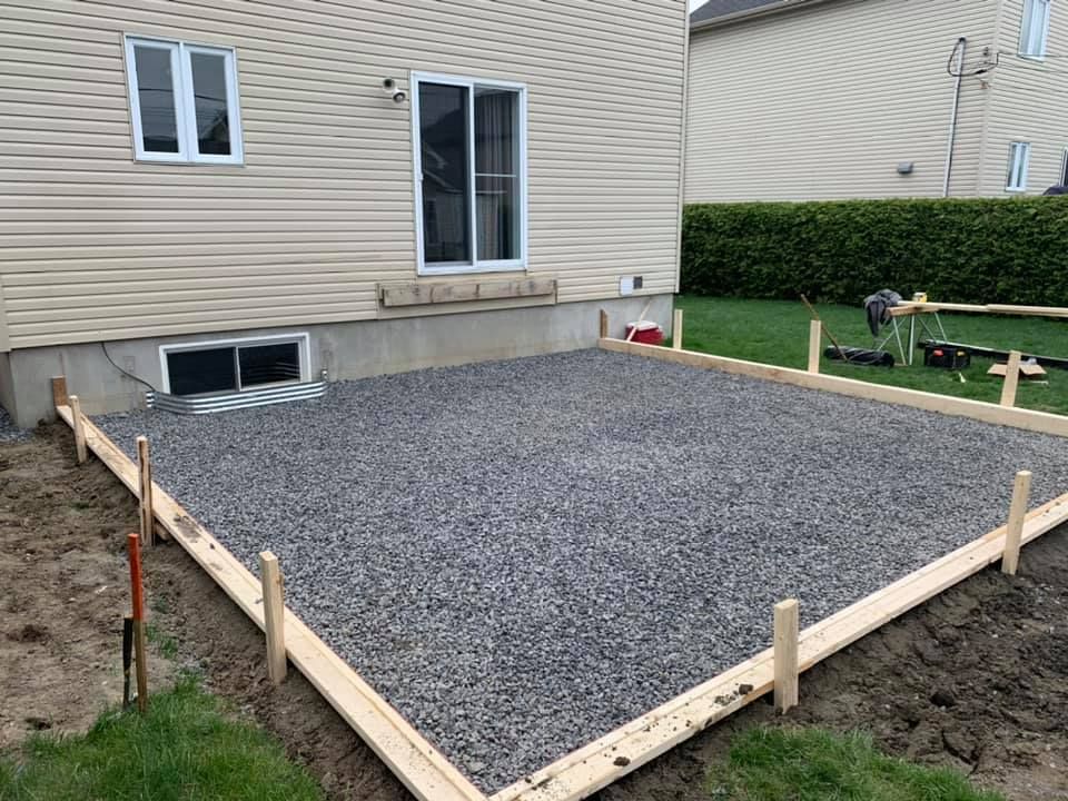 Une zone de gravier devant une maison est en cours de construction.