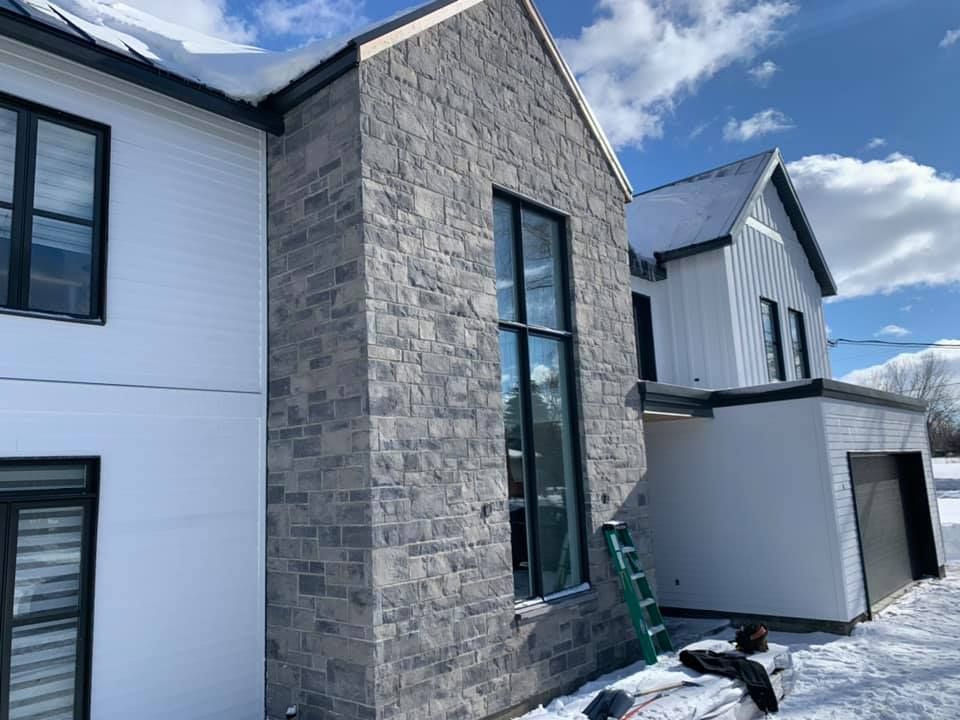 Une grande maison blanche avec une échelle devant elle dans la neige.